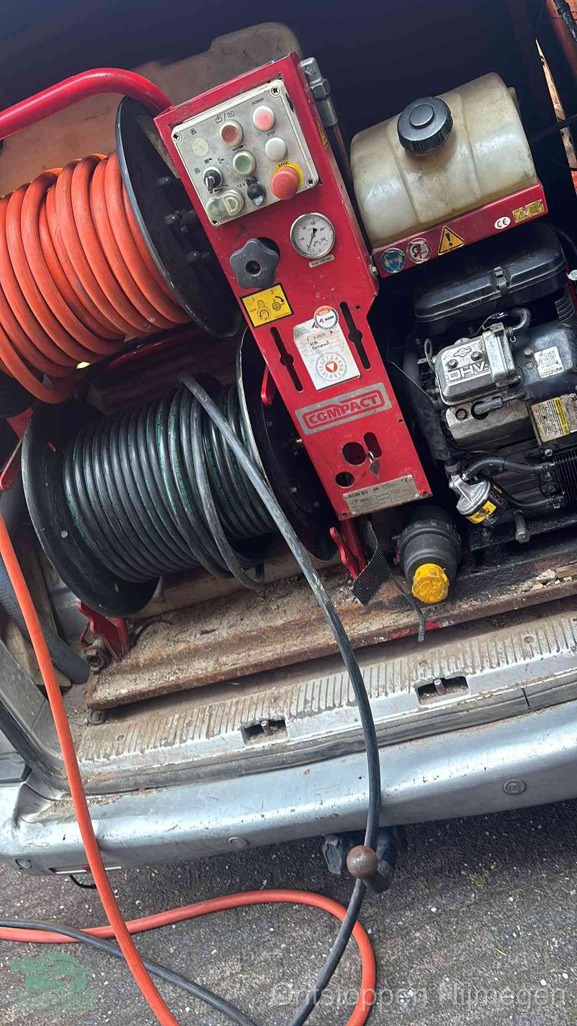 Een rood hogedruk-rioolreinigingstoestel in de laadbak van de bedrijfsbus, apparatuur voor een hardnekkige afvoerverstopping in Nijmegen