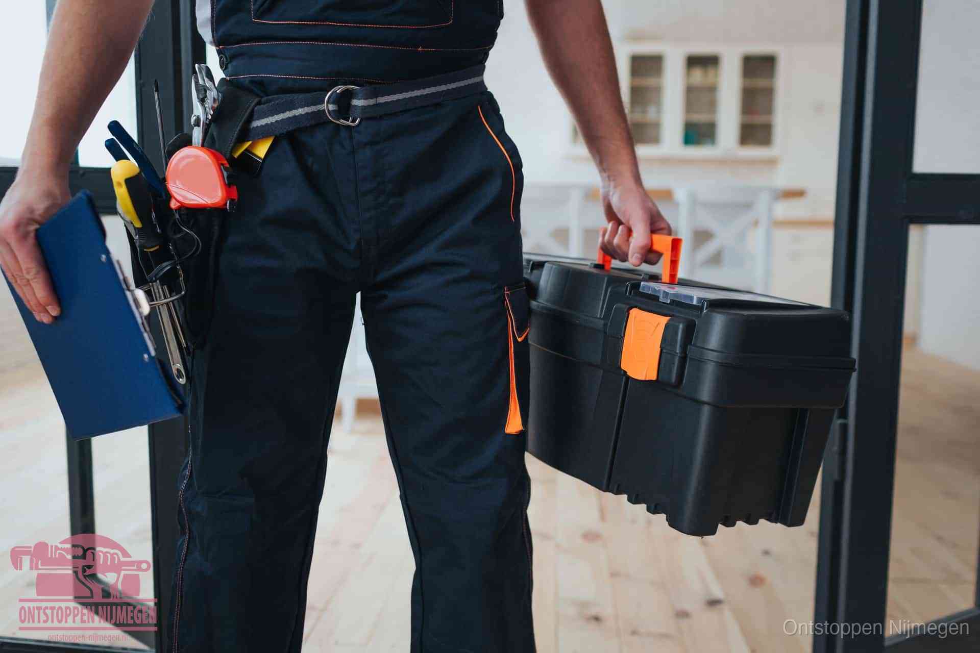 Een monteur met gereedschapsriem en klembord in een keuken, klaar om een transparante prijs voor het gootsteen ontstoppen in Nijmegen te geven
