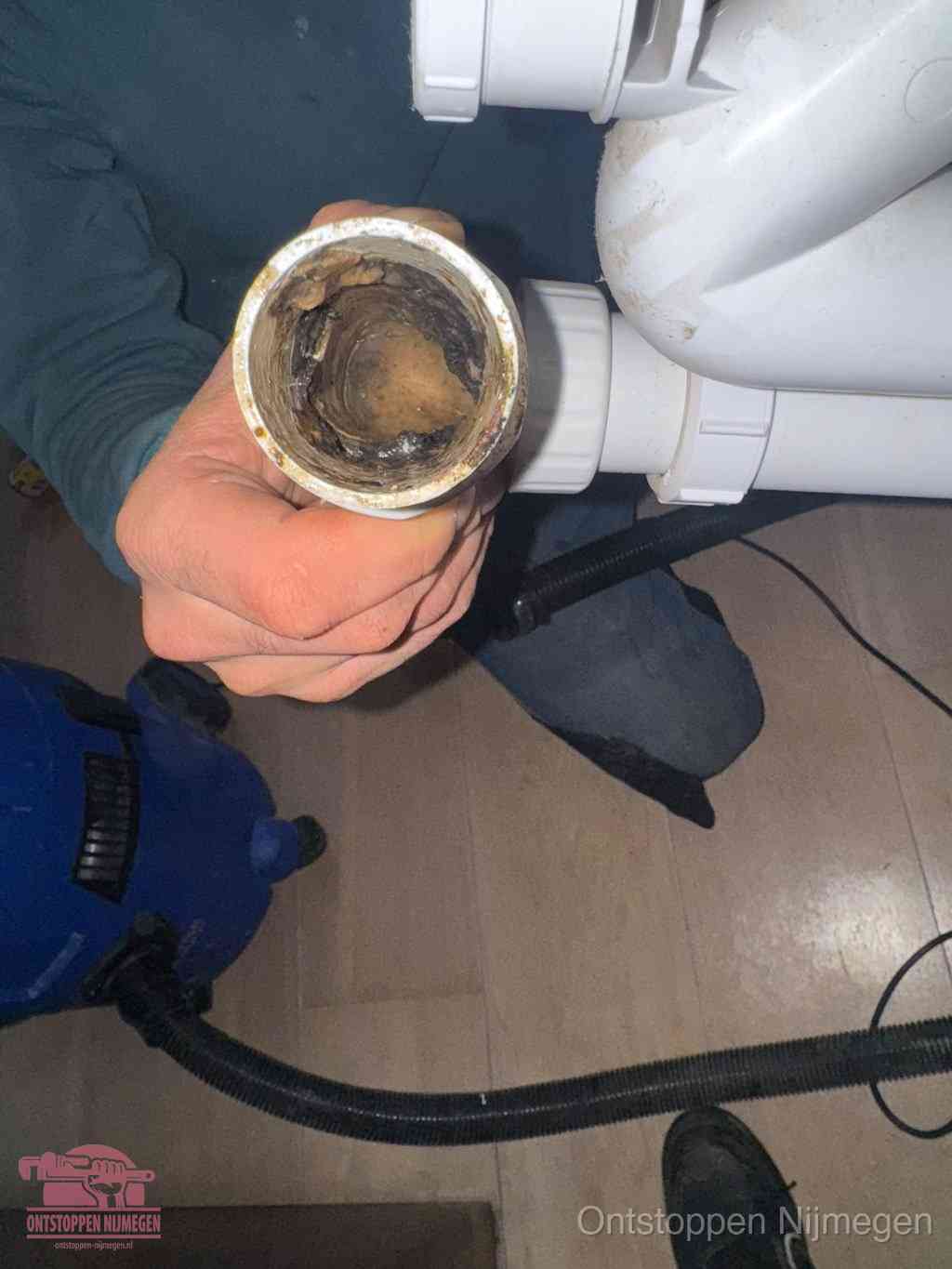 Een losgekoppelde afvoerbuis die van binnen volledig is dichtgeslibd met vet en aanslag, de meest voorkomende oorzaak van een verstopte gootsteen in Nijmegen