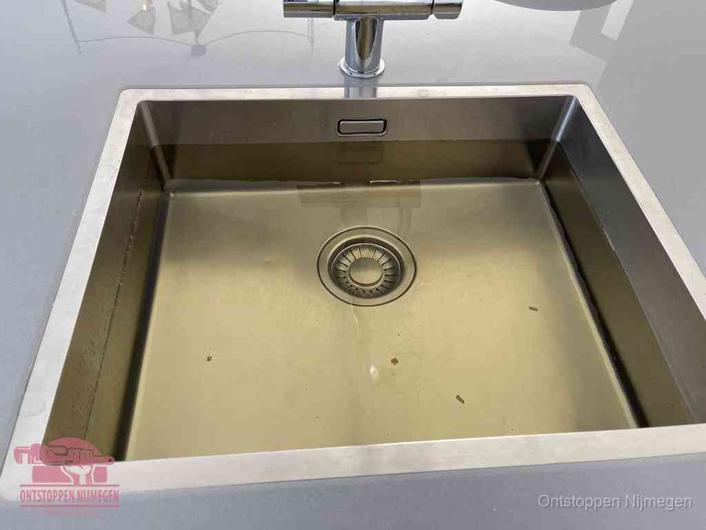 Stilstaand water in een rvs spoelbak dat niet wegloopt, een duidelijk signaal van een gootsteenverstopping in Nijmegen