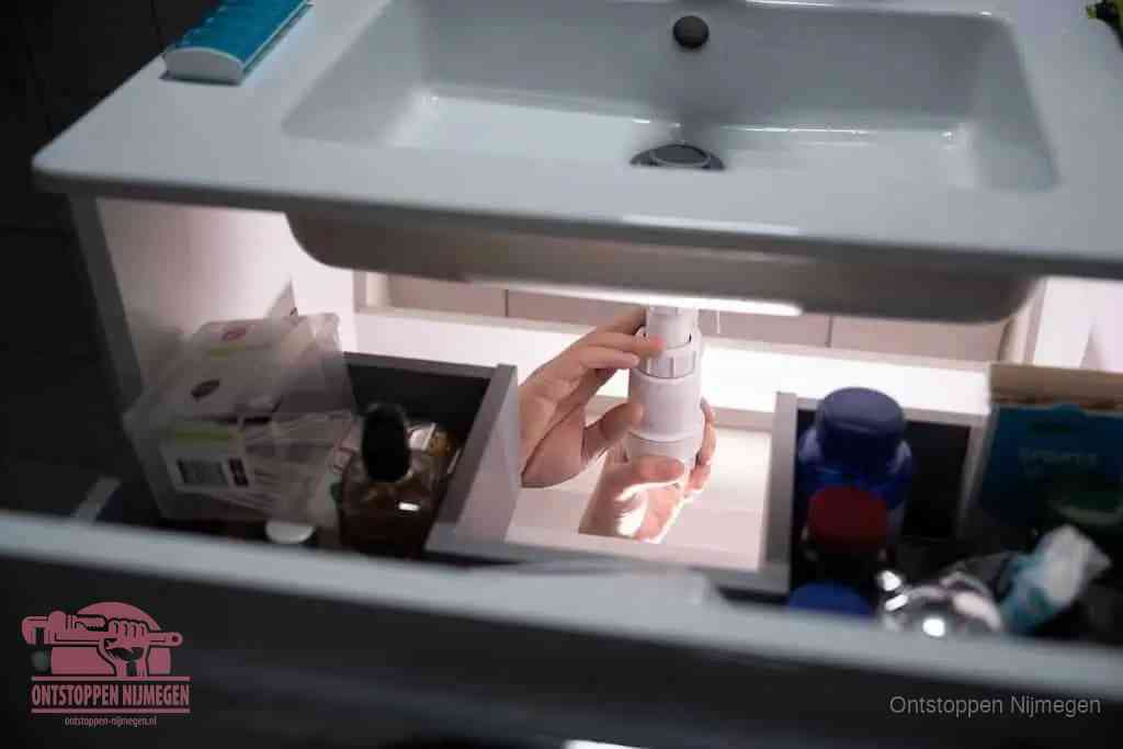 Een pompfles met zeep boven een wastafel in de toiletruimte, de warm water en afwasmiddel-methode om de wc te ontstoppen in Nijmegen